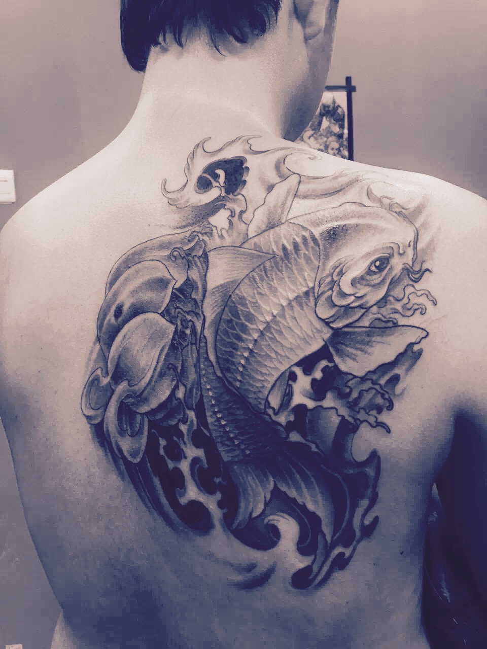 杭州潘先生背部的鲤鱼戏水纹身图案